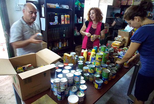 Volunteers talk, unload boxes, sort cans, and stock the shelves