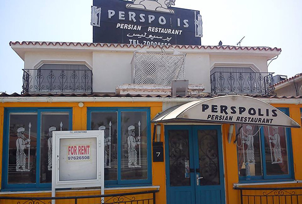 A "For Rent" sign replaces a menu outside a closed restaurant, now a regular sight in Larnaca, Cyprus