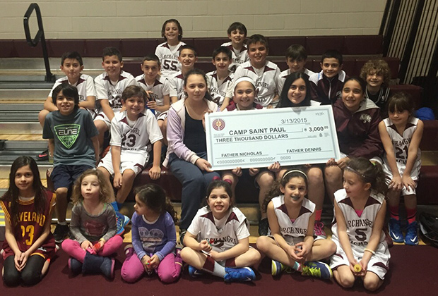 Children of the Archangel Michael Community holding the check to St. Paul Camp