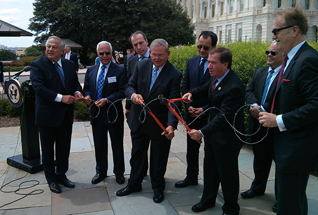 The Chairmen of the Senate Foreign Relations Committee and the House Foreign Affairs Committee, Senator Bob Menendez (D-NJ) and Congressman Ed Royce (R-CA) cut barbed wire to symbolize the desire of the US Congress to end the division and occupation of Cyprus after 40 years. With them (from L to R) are Philip Christopher, Costas Tsentas, Ambassador of Greece to the US Christos Panagopoulos, Ambassador of Cyprus to the US George Chacalli and Andy Manatos, at last year's conference. PHOTO: ETA PRESS