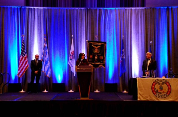 Dr. Laura Calamos Nasir accepting the Aristotle Award on behalf of her father, John Calamos, Sr.