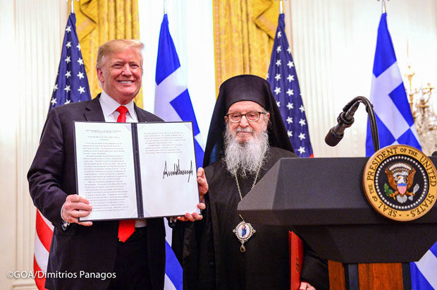 President Trump is holding the proclamation honoring Greek Independence, accompanied by Archbishop Demetrios